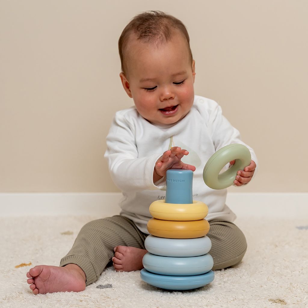 Baby speelt op de grond met de stapelringen van Little Dutch.