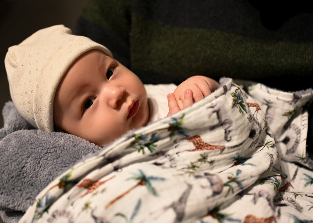 baby gewikkeld in teddy deken met jungle print