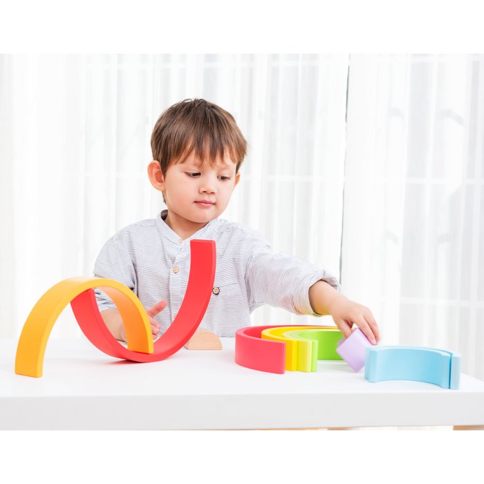 Kind speelt met de gekleurde houten regenboogwaaier
