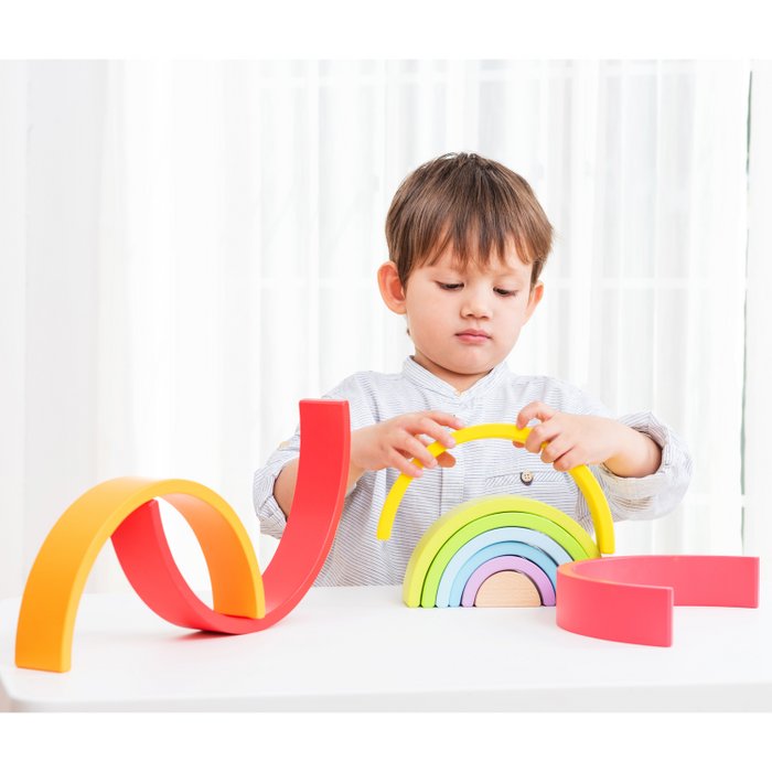 Kind speelt met de gekleurde houten regenboogwaaier